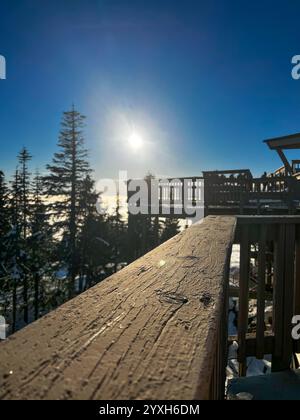 Garde-corps de pont d'observation au sommet de Grouse Mountain avec plate-forme d'observation silhouette contre le soleil d'hiver brillant, surplombant la mer de nuages ci-dessous Banque D'Images