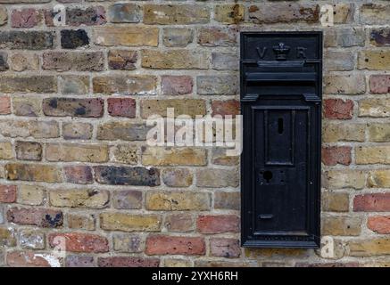 Une boîte aux lettres noire sur un mur de briques, The Avenue, Richmond-upon-Thames, Londres Banque D'Images