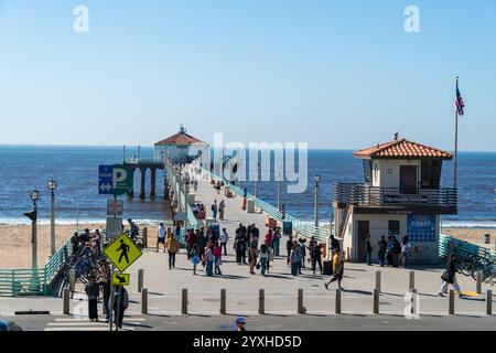 Des gens marchant sur la place d'entrée du Manhattan Beach Pier historique sous un ciel bleu clair à Los Angeles, en Californie Banque D'Images