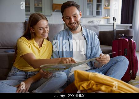 Heureux couple lisant la carte papier planifier des vacances de voyage Banque D'Images