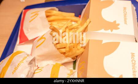 Gros plan sur les frites et hamburgers McDonald's, plateau de restauration rapide avec emballage pour sandwich Mcicken, frites, repas à disposition, déjeuner au restaurant à service rapide Banque D'Images