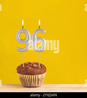 Cupcake au chocolat avec numéro 96 bougie - anniversaire sur fond jaune. Banque D'Images