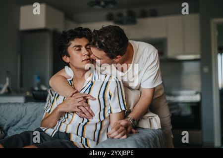 Un couple gay aimant embrasse dans un moment chaleureux et intime à la maison, exprimant affection et proximité. Banque D'Images