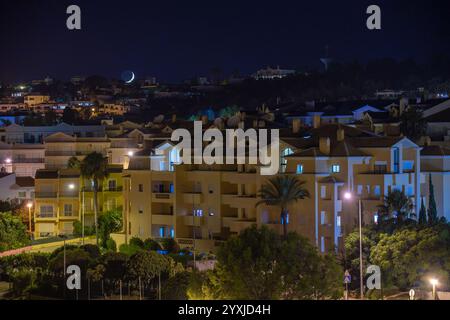 Image de nuit avec le croissant de lune et la foudre dans le village de luz dans la ville de Lagos en Algarve Banque D'Images