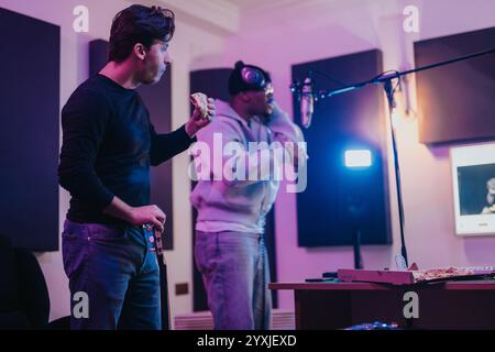 Deux musiciens collaborant dans un studio d’enregistrement professionnel lors d’une pause repas Banque D'Images