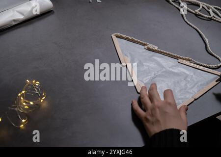 Bâtonnets de crème glacée arbre de Noël préparation durable processus de bricolage faisant la décoration à la main. Activité étape par étape pour les enfants. Passe-temps inclusif et responsable de vacances de soulagement du stress. Célébration consciente Banque D'Images