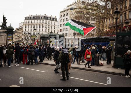 Paris, France. 14 décembre 2024. Un manifestant tient un drapeau palestinien pendant la manifestation pro-palestinienne. Des centaines de personnes ont pris part à une manifestation pro-palestinienne organisée par le collectif urgence Palestine, à Paris. Crédit : SOPA images Limited/Alamy Live News Banque D'Images