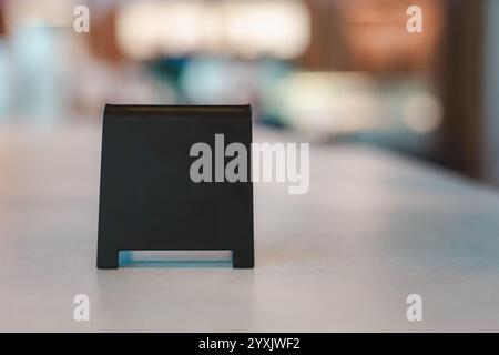 Un panneau noir vierge est placé sur une table de ciment pour entrer le texte de votre restaurant, magasin ou café. Banque D'Images