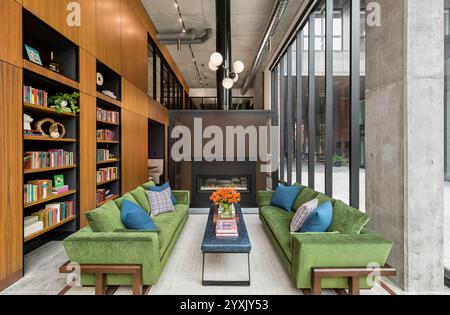 Grand hall de deux étages d'un immeuble d'appartements avec coin salon et bibliothèques intégrées Banque D'Images