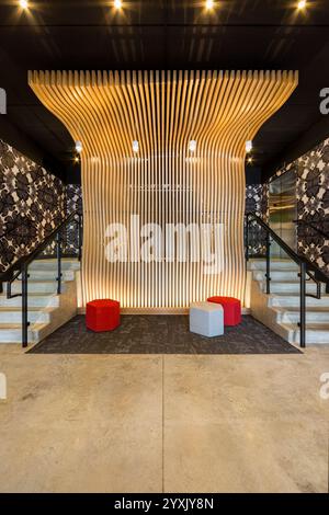 Hall d'entrée du nouvel immeuble d'appartements avec unique "mur de vague" en bois coupé au laser Banque D'Images