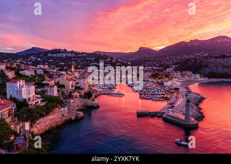 Port de Cassis, Un port magnifique au lever du soleil offre un ciel vibrant au-dessus d'une ville côtière méditerranéenne pittoresque. Banque D'Images