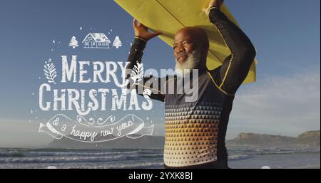 Image du texte de voeux de noël sur l'homme afro-américain avec planche de surf sur la plage. Noël, tradition, célébration et concept de fête numériquement Banque D'Images