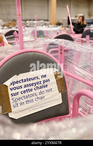 Kaiserslautern, Allemagne. 17 décembre 2024. Un employé se tient derrière des chaises d'arbitre dans un entrepôt. Des milliers d'objets des Jeux olympiques d'été à Paris sont remis d'un entrepôt aux soumissionnaires retenus après une vente aux enchères sur Internet. Une entreprise avait acheté 50 000 articles - des canapés aux parasols et des chaises d'arbitre au baby-foot - pour donner une seconde vie au matériel. Crédit : Uwe Anspach/dpa/Alamy Live News Banque D'Images