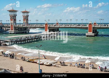 Stanley Bridge à Alexandrie, Egypte, surplombant la mer Méditerranée animée, avec des plages de sable, des bateaux colorés et des touristes sur la côte ensoleillée. Banque D'Images