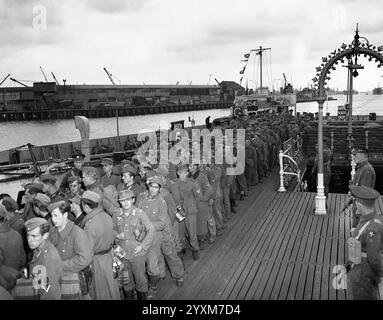 Des prisonniers de guerre allemands débarquent d'un LCT britannique (portant le numéro 3546) dans un port anglais, après leur capture en Normandie, juin 1944. Photographié peu après le débarquement de Normandie - photo de la Garde côtière américaine Banque D'Images