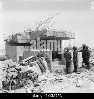 Les troupes inspectent un canon allemand de 50 mm abattu dans son emplacement sur Gold Beach - Midgley (Sgt), No 5 Army film & Photographic Unit, jour J 6 juin 1944 Banque D'Images