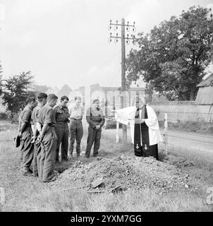 La campagne alliée dans le Nord-Ouest de l'Europe- 6 juin 1944 - 7 mai 1945 à côté de la route de Lesieux en Normandie, un aumônier de l'armée britannique préside à l'enterrement d'un soldat tombé alors que les chars du 8e Hussars continuent l'avance - photo de Wilkes Banque D'Images