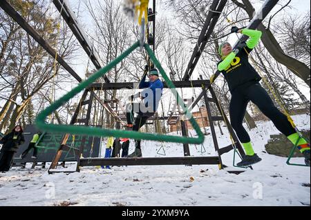 LVIV, UKRAINE - 14 DÉCEMBRE 2024 - les concurrents passent un obstacle lors de la cinquième course Kordon dans le parc de culture et de loisirs Bohdan Khmelnytskyi, Lviv, dans l'ouest de l'Ukraine. La Kordon Race est à la fois une course à obstacles et des masterclasses visant à s’adapter à la vie dans un pays en guerre. Banque D'Images