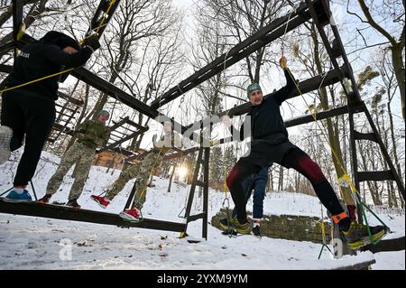 LVIV, UKRAINE - 14 DÉCEMBRE 2024 - les concurrents passent un obstacle lors de la cinquième course Kordon dans le parc de culture et de loisirs Bohdan Khmelnytskyi, Lviv, dans l'ouest de l'Ukraine. La Kordon Race est à la fois une course à obstacles et des masterclasses visant à s’adapter à la vie dans un pays en guerre. Banque D'Images