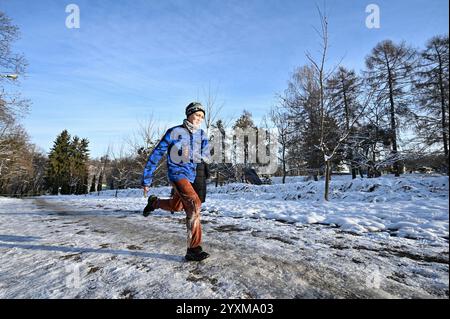 LVIV, UKRAINE - 14 DÉCEMBRE 2024 - Un garçon court pendant la cinquième course Kordon dans le parc de culture et de loisirs Bohdan Khmelnytskyi, Lviv, dans l'ouest de l'Ukraine. La Kordon Race est à la fois une course à obstacles et des masterclasses visant à s’adapter à la vie dans un pays en guerre. Banque D'Images