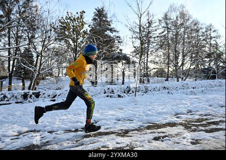 LVIV, UKRAINE - 14 DÉCEMBRE 2024 - Un garçon court pendant la cinquième course Kordon dans le parc de culture et de loisirs Bohdan Khmelnytskyi, Lviv, dans l'ouest de l'Ukraine. La Kordon Race est à la fois une course à obstacles et des masterclasses visant à s’adapter à la vie dans un pays en guerre. Banque D'Images