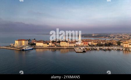Vue aérienne imprenable sur la marina de Poreč au crépuscule, mettant en évidence l'architecture du front de mer de la ville historique et les eaux calmes de l'Adriatique. Banque D'Images