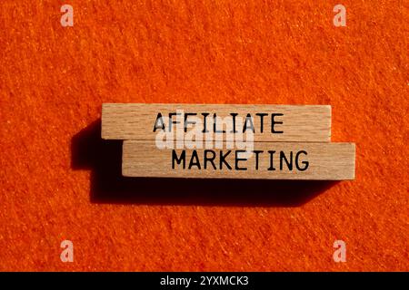 Message de marketing d'affiliation écrit sur des blocs de bois avec fond orange. Symbole conceptuel de marketing d'affiliation. Copier l'espace. Banque D'Images