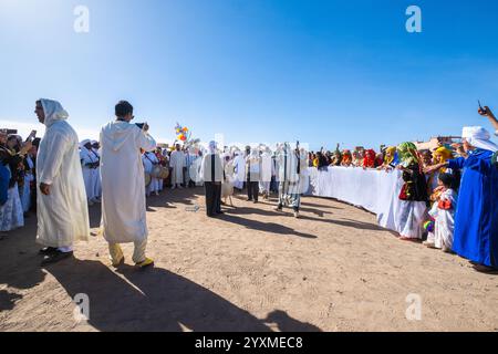 Merzouga, Maroc, 12, 6, 2023. Un mariage berbère traditionnel a lieu à la périphérie du village. deux hommes portent un agneau à sacrifier. hommes o Banque D'Images