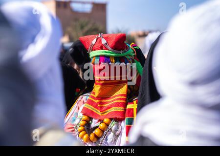 Merzouga, Maroc, 12, 6, 2023. Une jeune mariée en deuil sous le soleil entourée de femmes vêtues de costumes de gala traditionnels. Une mariée berbère traditionnelle Banque D'Images