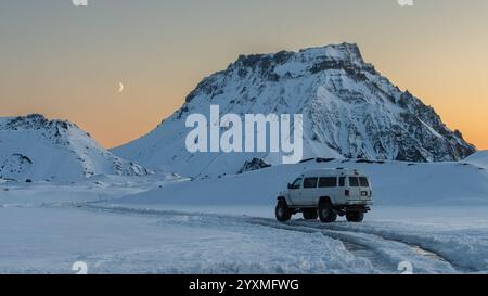 Véhicule sur un sentier à travers le glacier Myrdalsjokull, sur la côte sud de l'Islande. Beau coucher de soleil dans les montagnes, paysage d'hiver en Islande. Banque D'Images
