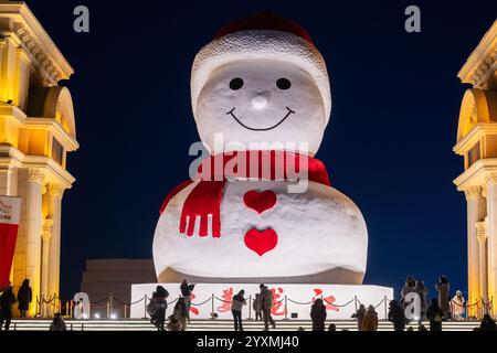 Harbin, province chinoise du Heilongjiang. 17 décembre 2024. Les touristes voient un bonhomme de neige géant à Harbin, dans la province du Heilongjiang du nord-est de la Chine, Dec. 17, 2024. Crédit : Zhang Tao/Xinhua/Alamy Live News Banque D'Images