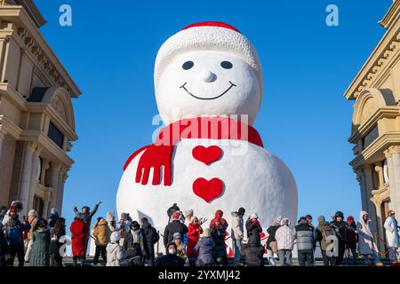 Harbin, province chinoise du Heilongjiang. 17 décembre 2024. Les touristes voient un bonhomme de neige géant à Harbin, dans la province du Heilongjiang du nord-est de la Chine, Dec. 17, 2024. Crédit : Zhang Tao/Xinhua/Alamy Live News Banque D'Images