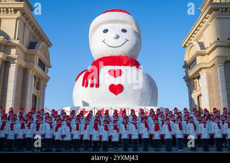 Harbin, province chinoise du Heilongjiang. 17 décembre 2024. Des élèves pimentent devant un bonhomme de neige géant à Harbin, dans la province du Heilongjiang, au nord-est de la Chine, 17 décembre 2024. Crédit : Zhang Tao/Xinhua/Alamy Live News Banque D'Images