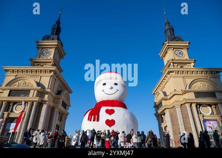 Harbin, province chinoise du Heilongjiang. 17 décembre 2024. Les touristes voient un bonhomme de neige géant à Harbin, dans la province du Heilongjiang du nord-est de la Chine, Dec. 17, 2024. Crédit : Zhang Tao/Xinhua/Alamy Live News Banque D'Images