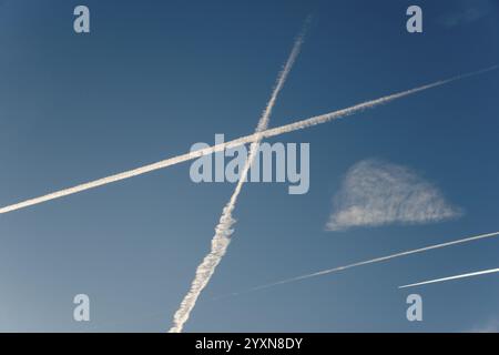 Des traînées de condensation d'avions se croisent dans un ciel bleu clair et forment des motifs géométriques, basse-Saxe, Allemagne, Europe Banque D'Images