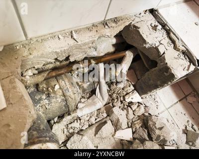 Tuyau d'eaux usées d'une toilette, arrivée d'eau, chantier de construction d'une salle de bain après une fuite dans un tuyau Banque D'Images