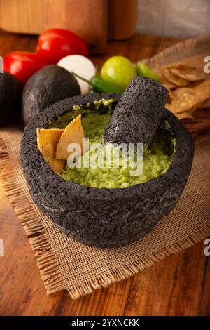 Guacamole. La sauce DIP à l'avocat, l'une de ses nombreuses façons de la consommer, est étalée sur des chips tortilla également appelées Nachos. Recette de sauce maison facile mexicaine Banque D'Images