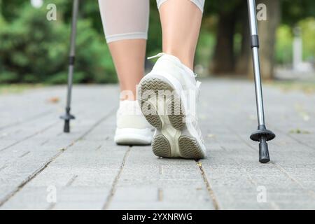 Femme sportive faisant de la marche nordique dans la rue, gros plan Banque D'Images