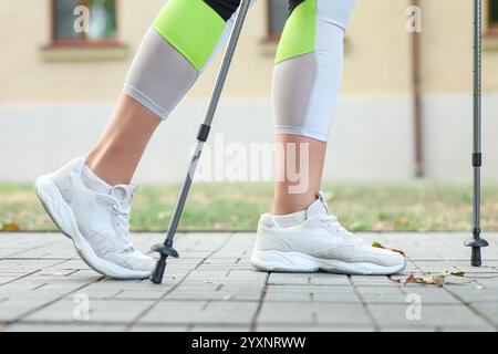 Femme sportive faisant de la marche nordique dans la rue, gros plan Banque D'Images