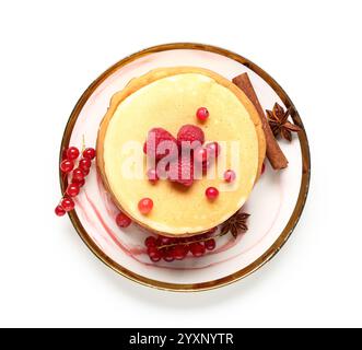 Assiette de crêpes sucrées avec framboises, groseilles rouges et cannelle sur fond blanc Banque D'Images