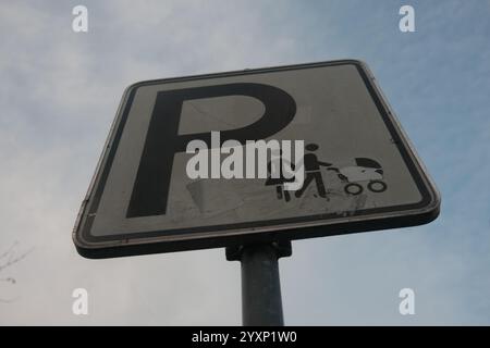 Un panneau avec un couple et une poussette dessus et la lettre P. le panneau est sur un poteau Banque D'Images