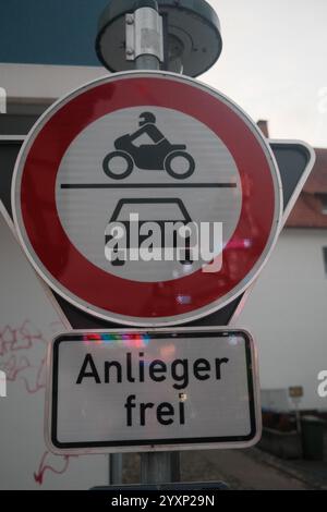 Un panneau avec un cercle rouge et un cercle blanc avec une moto et une voiture dedans. Le panneau dit "Anliegener Frei" en allemand Banque D'Images