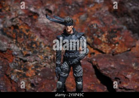 Metal Gear Solid action Figurine scène extérieure fond en métal rouillé vue de trois quarts 2 Banque D'Images