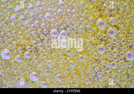 Fond abstrait vibrant avec des bulles jaunes avec des reflets violets subtils. Parfait pour les projets de conception créatifs, les visuels scientifiques et modernes Banque D'Images