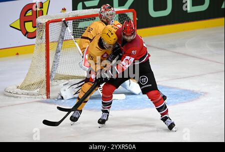 Bremerhaven, Allemagne. 17 décembre 2024. Hockey sur glace : Ligue des Champions, Pinguins Bremerhaven - Servette Genève, finale, quarts de finale, deuxième manche. Le gardien de Genève Antti Raanta derrière Roger Karren de Genève et Miha Verlic de Bremerhaven (R). Crédit : Stringer/dpa/Alamy Live News Banque D'Images