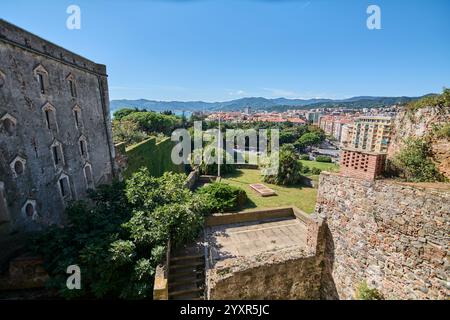 Savona. Italie - 17 décembre 2024 : ruines de pierre à Savone surplombant le paysage urbain moderne, avec un dôme d'église et des montagnes au-delà. Concept : Juxtapos Banque D'Images