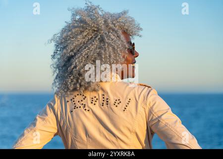 Gros plan arrière d'une dame afro-américaine portant une veste avec le mot rebelle. Concept : pro-âge, rebelle Banque D'Images