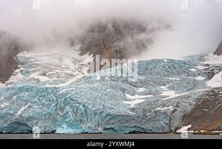 Énorme glacier sortant des nuages et dans la mer à Brepollen, Hornsund dans les îles Svalbard Banque D'Images