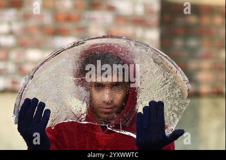 Srinagar, Inde. 17 décembre 2024. SRINAGAR, INDE - 17 DÉCEMBRE : un garçon montre un morceau de glace gelée par un froid matin d'hiver le 17 décembre 2024 à Srinagar, Inde. Cold Wave saisit le Cachemire, car Srinagar enregistre une température minimale à moins 5,3 degrés celcius. (Photo de Waseem Andrabi/Hindustan Times/Sipa USA) crédit : Sipa USA/Alamy Live News Banque D'Images