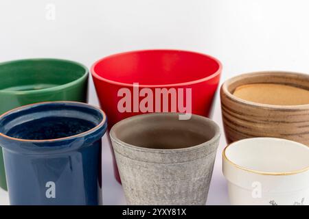 Différentes tailles et couleurs de pots de fleurs isolés sur un fond blanc. Vert, rouge, marron, bleu, gris et blanc, pots vides en céramique sur fond blanc Banque D'Images